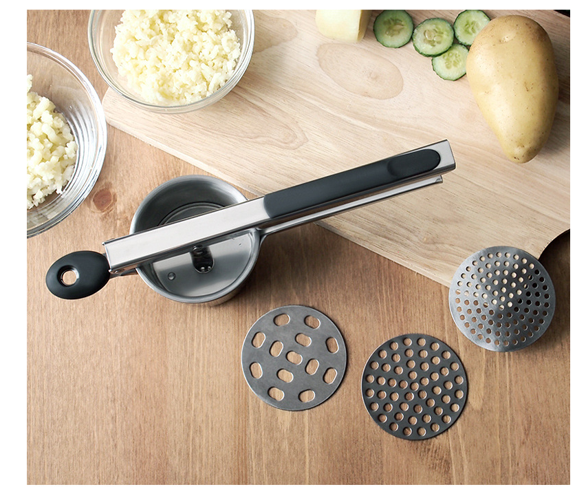 Top-down view of the ricer with interchangeable discs and fresh produce