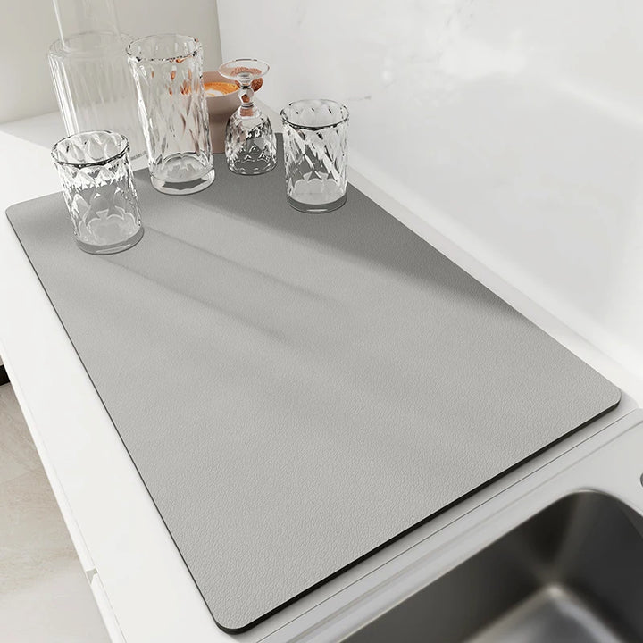 Solid gray stone dish drying mat on a kitchen counter