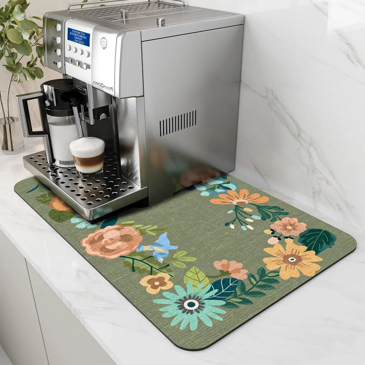 Sage green coffee mat with floral border under an espresso machine