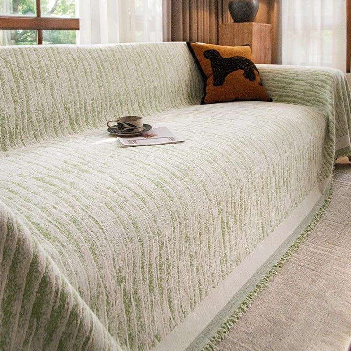 Waterproof sofa cover protecting a three-seater couch in a living room