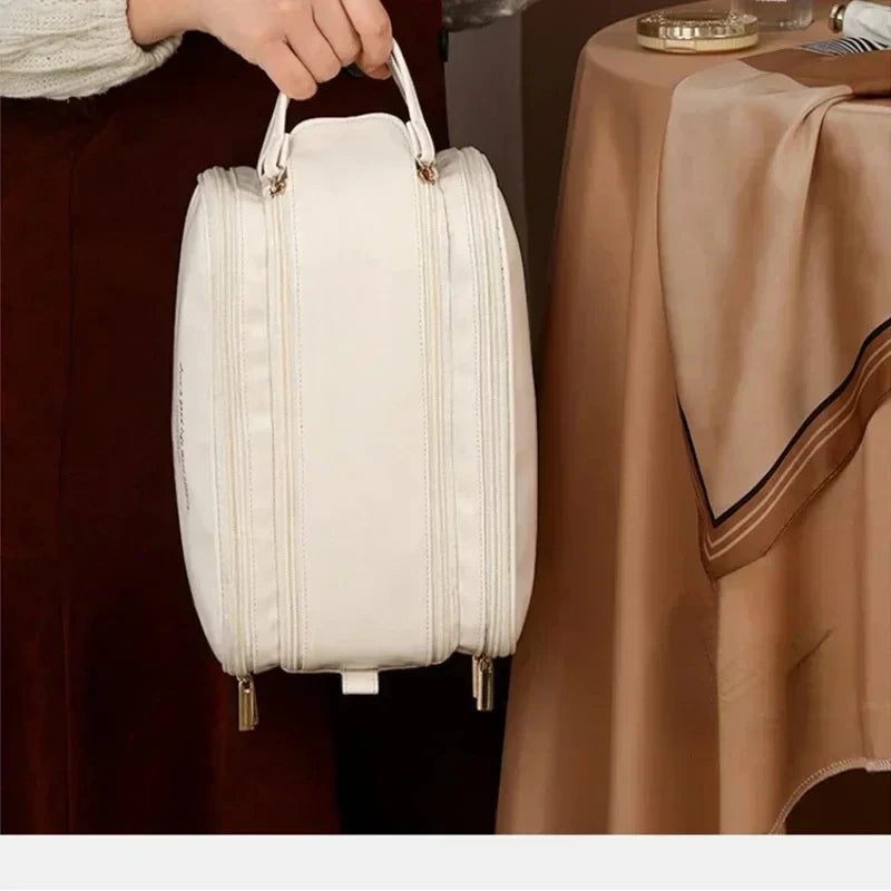 Beige travel makeup bag carried by its handle